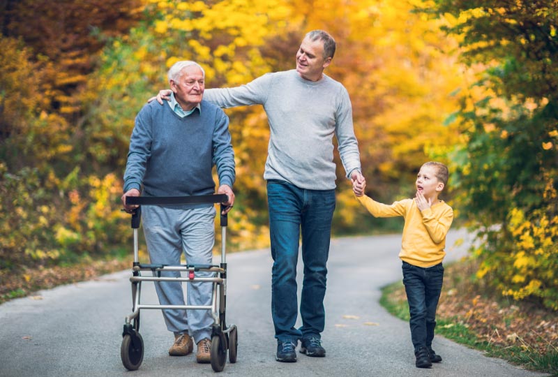 Elderly man with walker, man and son