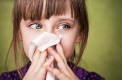 Stock photo of a little girl blowing her nose