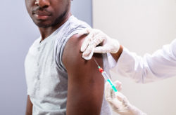 Stock photo of Close-up Of Doctor Injecting Vaccine Into Patients Arm With Syringe