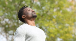 Stock photo of a Black serious man breathing deeply outside