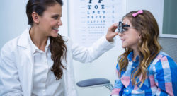 Stock photo of an ophthalmologist fitting a child for glasses