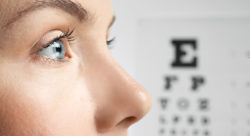 Stock photo of a woman's eyes closeup with an optometry chart in the background